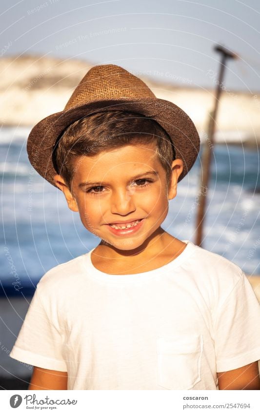 Portrait of a cute kid with hat in front of a ocean Lifestyle Joy Happy Beautiful Face Leisure and hobbies Vacation & Travel Summer Sun Beach Ocean Child