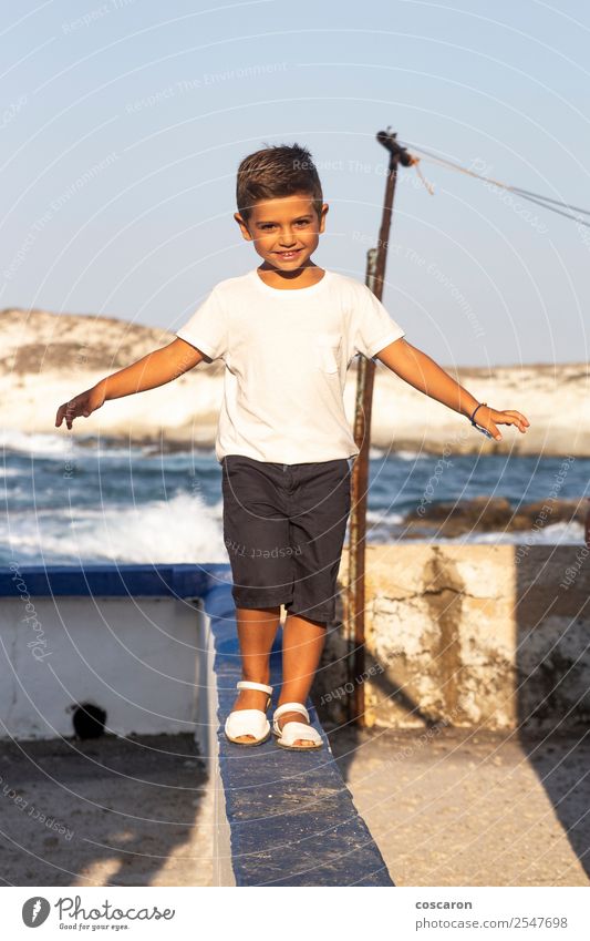 Cute boy doing balance on a wall in summer Lifestyle Joy Beautiful Leisure and hobbies Playing Adventure Summer Ocean Child Human being Masculine Baby