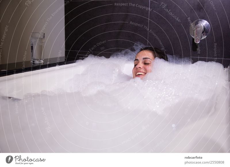 Women's legs in the bathtub, bathing with bubble bath foam top view,  relaxtion beauty spa concept - a Royalty Free Stock Photo from Photocase