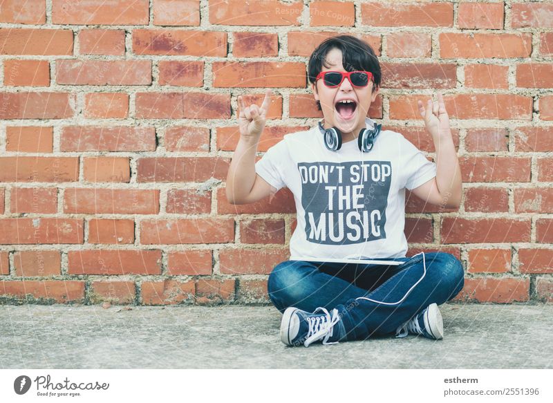 child with headphones connected with digital tablet Lifestyle Joy Playing Entertainment Music Headset MP3 player Technology Internet Human being Masculine Child