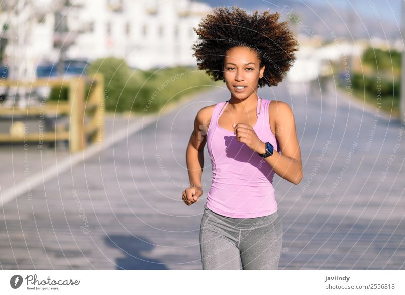 Black woman, afro hairstyle, running outdoors in urban road. Lifestyle Beautiful Hair and hairstyles Wellness Leisure and hobbies Sports Jogging Human being