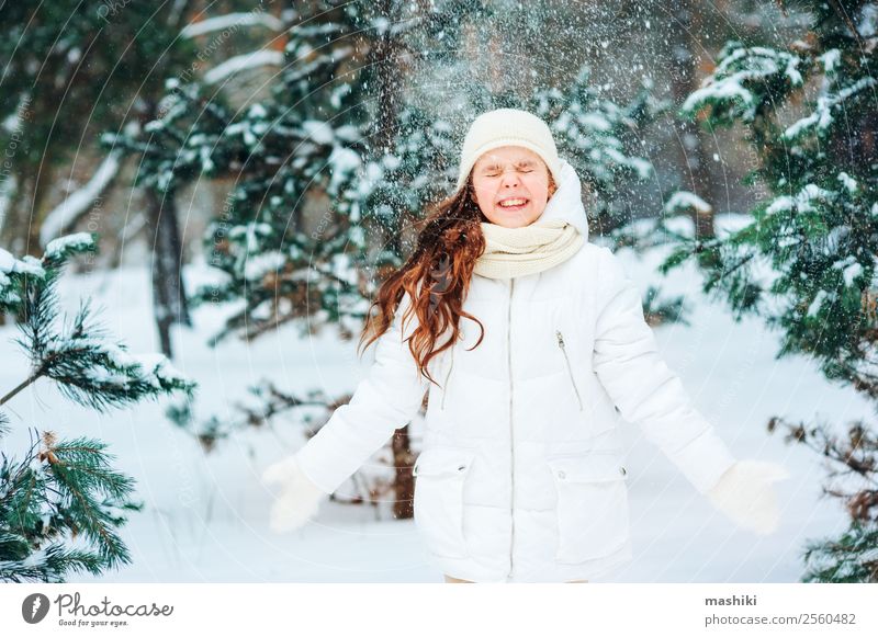 Winter portrait of happy child girl playing outdoor Joy Vacation & Travel Adventure Freedom Snow Child Infancy Nature Snowfall Tree Forest Clothing Hat To enjoy