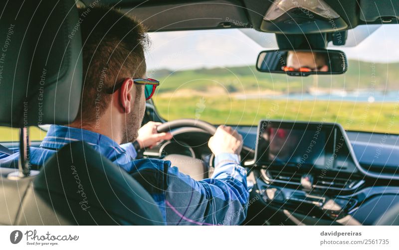 Young man holding steering driving Lifestyle Vacation & Travel Trip Adventure Screen Technology Human being Man Adults Arm Hand Grass Meadow Coast Transport