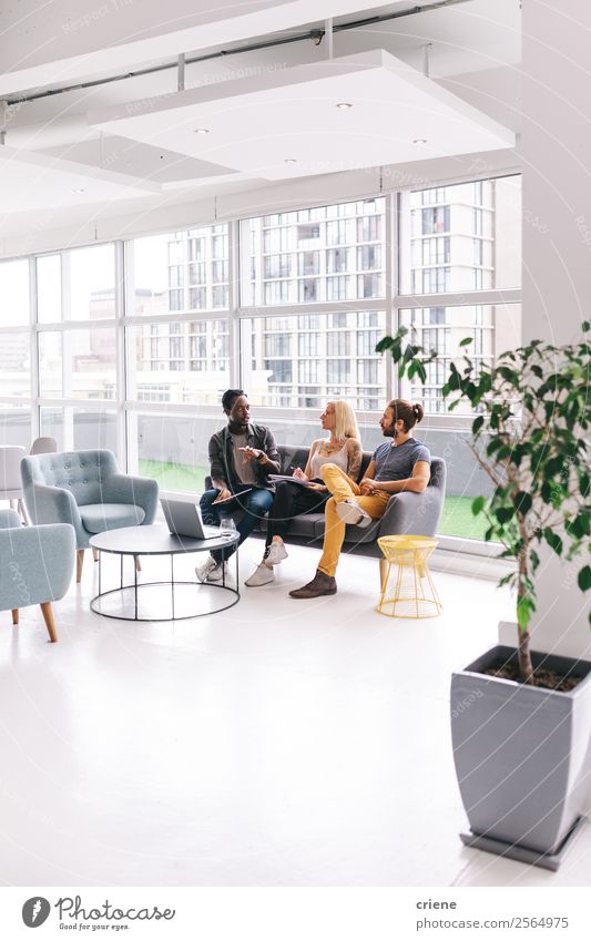 Group of young business people chatting in start-up office Lifestyle Decoration Table Work and employment Profession Office Business Company Meeting Computer