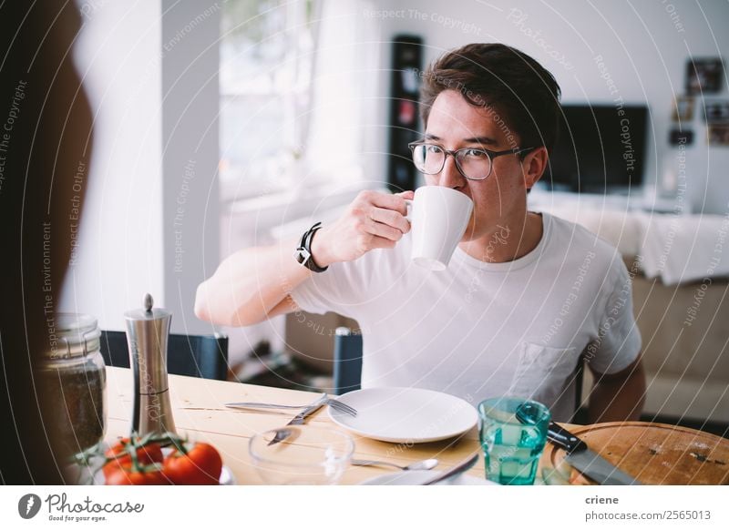 young asian man drinking coffee while having breakfast Vegetable Eating Breakfast Coffee Joy Beautiful Chair Table Kitchen To talk Human being Woman Adults Man