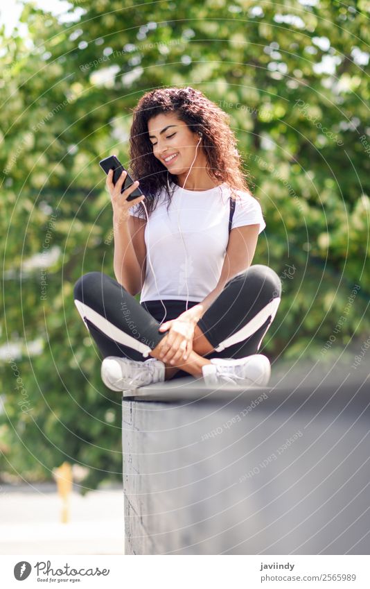 Beautiful African woman listening to music with earphones Lifestyle Style Happy Hair and hairstyles Music Sports Telephone PDA Technology Human being Feminine