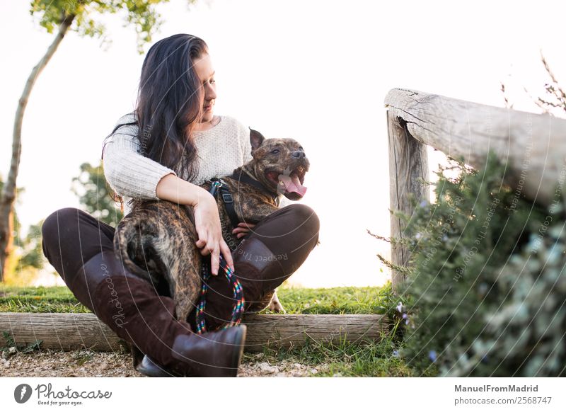 young woman with her dog at a park Lifestyle Happy Beautiful Woman Adults Friendship Nature Animal Grass Park Pet Dog Smiling Friendliness Together Natural Cute