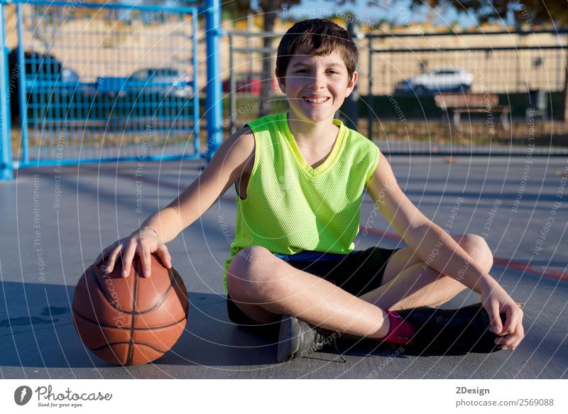 Young basketball player sitting on the court Lifestyle Joy Relaxation Leisure and hobbies Playing Sports Boy (child) Man Adults Youth (Young adults) Street Sit