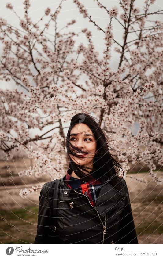 Brunette girl near a almond tree with many flowers Style Happy Beautiful Face Garden Human being Woman Adults Nature Tree Flower Blossom Park Fashion Jacket