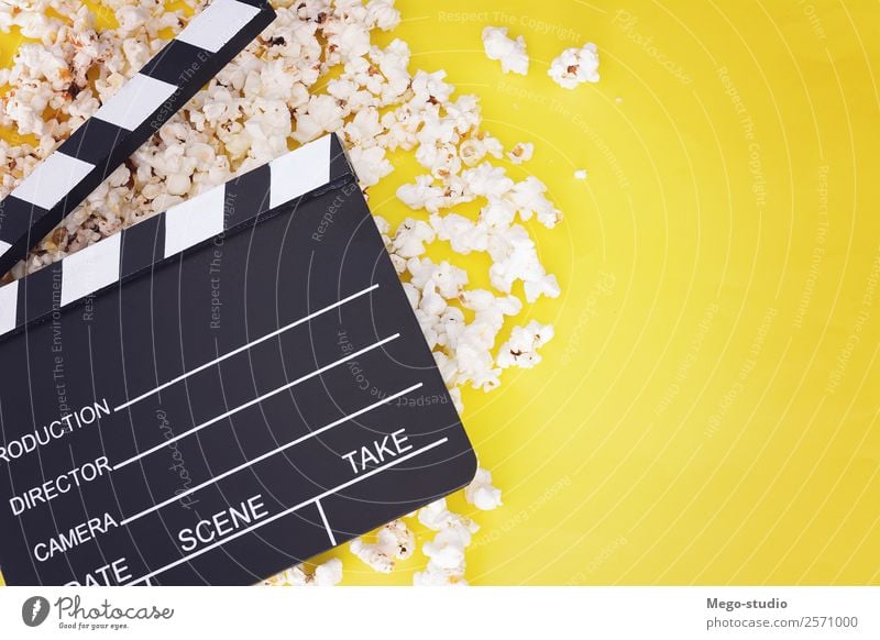popcorn and clapboard on yellow background. Cinema concept Fast food Bowl Joy Leisure and hobbies Entertainment Industry Theatre Media Television Wood Observe