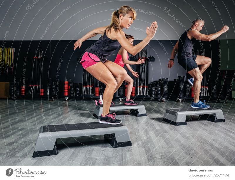 Woman trainer doing aerobic class with steppers in gym Lifestyle Happy Beautiful Sports Human being Adults Man Friendship Group Fitness Jump Authentic Eroticism