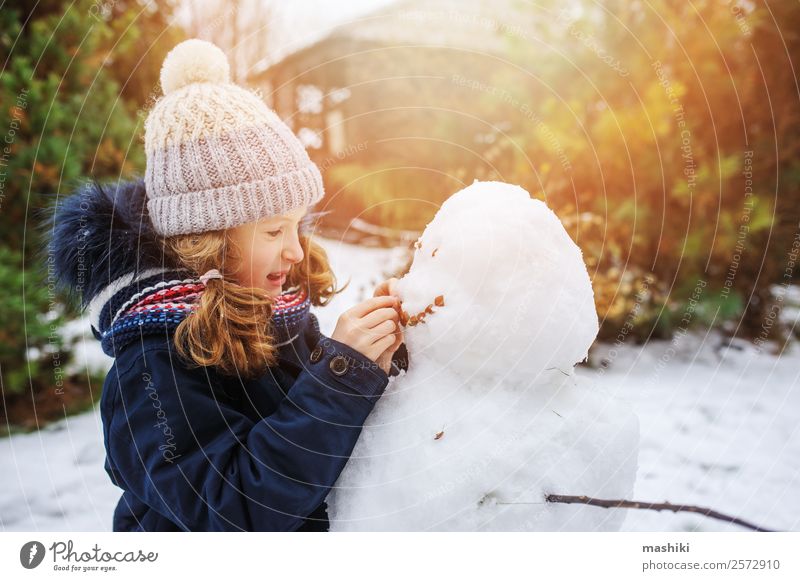 happy kid girl making snow man on Christmas vacations Joy Leisure and hobbies Playing Vacation & Travel Winter Snow Winter vacation Garden Child Nature Weather