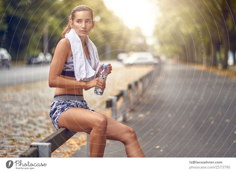 Happy woman taking a break from jogging. Drinking Lifestyle Summer Sports Jogging Woman Adults 1 Human being 18 - 30 years Youth (Young adults) Warmth Street
