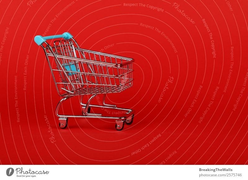 Close up empty toy supermarket shopping cart over red Shopping Economy Trade Logistics Business Toys Metal Plastic Red Colour Retail sector Supermarket Side