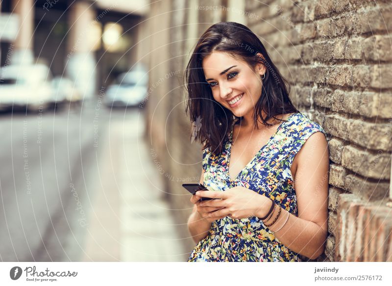 Smiling young woman using her smart phone outdoors Lifestyle Style Happy Beautiful Hair and hairstyles Telephone PDA Technology Human being Feminine Young woman