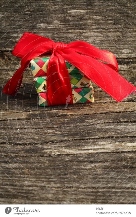 Surprise l colorful Christmas parcels packed with Christmas paper with red bow, lying on rustic wood. Christmas presents, lie nicely decorated with ribbon on wooden table. Many Christmas parcels packed with wrapping paper with Christmas motif.