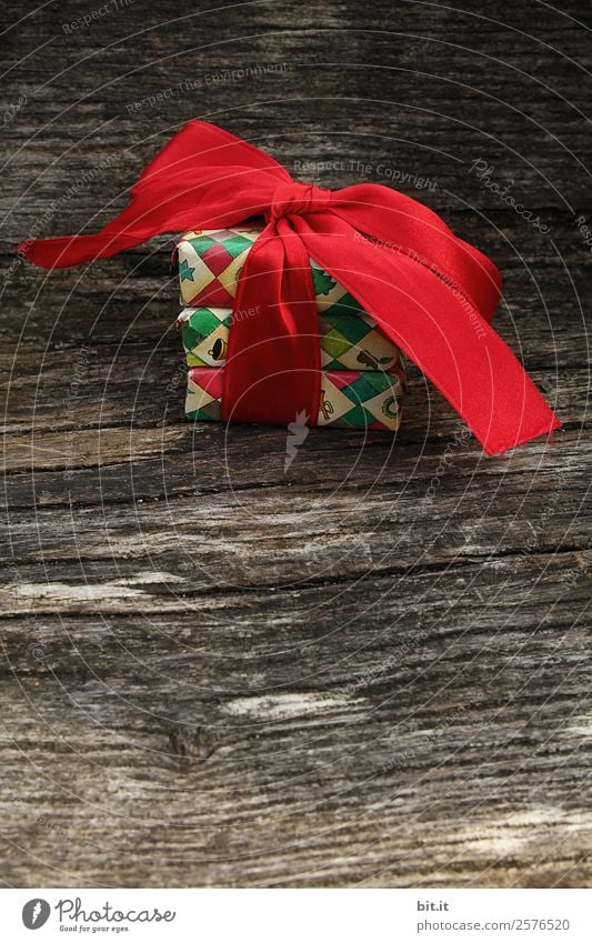 colourful christmas parcels packed with christmas paper with red bow, on rustic wood. Christmas presents, lie nicely decorated with ribbon on wooden table. Many Christmas parcels wrapped with wrapping paper with Christmas motif. Concept gifts Advent.