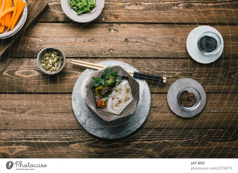 Geometric bowl of Asian Noodle Soup with chopsticks Food Meat Vegetable Stew Nutrition Eating Lunch Dinner Asian Food Bowl Table Wood Fresh Delicious Green