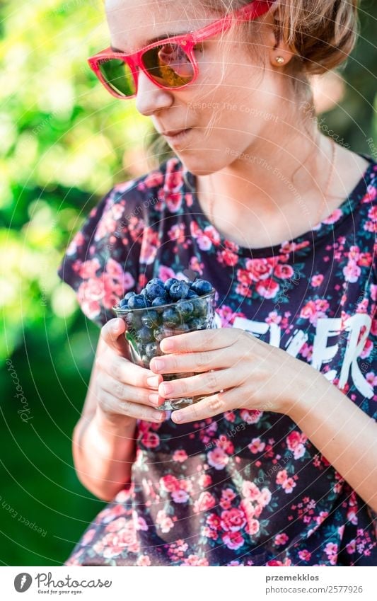 Happy girl enjoying eating the fresh blueberries Food Fruit Nutrition Eating Vegetarian diet Diet Glass Lifestyle Summer Garden Human being Young woman