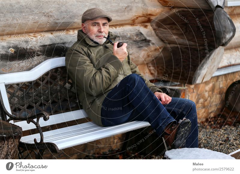 The man smokes a pipe. Man Sit Bench Smoking Tobacco products Pipe House (Residential Structure) Cold Winter Wood Smoke Facial hair Adults Human being
