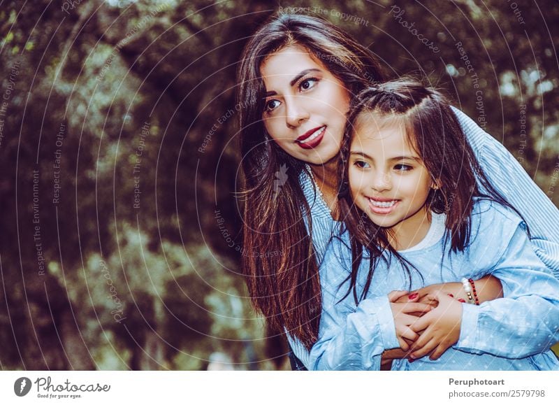 Mother carrying her cute and smiling daughter in the park Human being Feminine Child Baby Girl Young woman Youth (Young adults) Woman Adults Parents