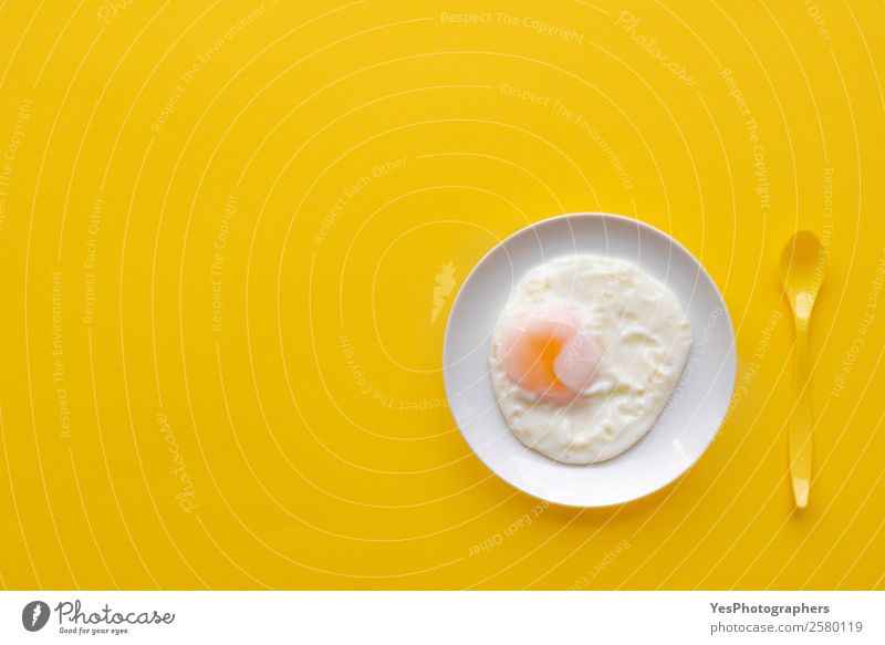 Fried egg in a plate on a yellow background Food Nutrition Breakfast Lunch Buffet Brunch Diet Plate Spoon Elegant Table Kitchen Esthetic Fresh Bright Delicious