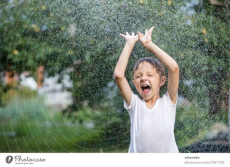 Happy little boy pouring water from a hose. Joy Leisure and hobbies Playing Vacation & Travel Freedom Camping Summer House (Residential Structure) Garden Child
