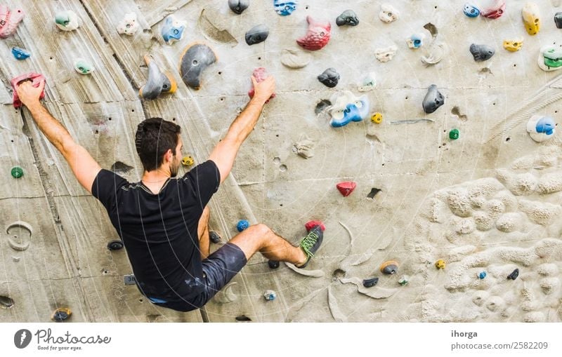 A Man practicing rock climbing on artificial wall indoors Lifestyle Joy Leisure and hobbies Sports Climbing Mountaineering Young man Youth (Young adults) Adults