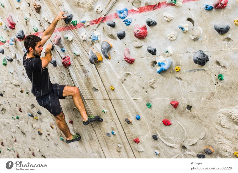 A Man practicing rock climbing on artificial wall indoors Lifestyle Joy Leisure and hobbies Sports Climbing Mountaineering Adults 1 Human being 18 - 30 years