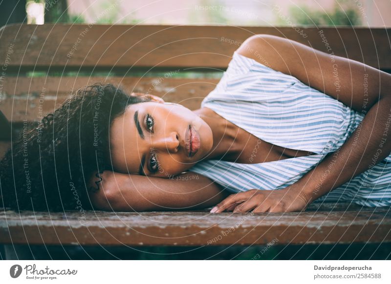 Beautiful young black woman laying down on a chair in a park Lifestyle Happy Relaxation Summer Garden Chair Woman Adults Nature Park Dress Lie Happiness Natural