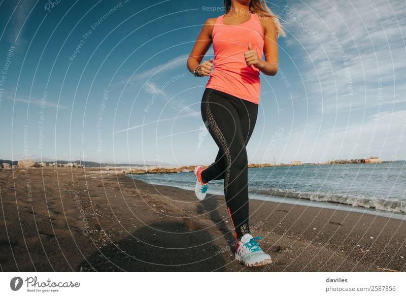 Woman with sports clothes running by the sea shore Lifestyle Health care Beach Ocean Sports Fitness Sports Training Sportsperson Jogging Human being Feminine