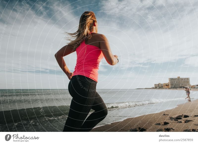 Woman with sports clothes running by the sea shore Lifestyle Joy Athletic Fitness Wellness Beach Ocean Sports Sports Training Jogging Human being Feminine