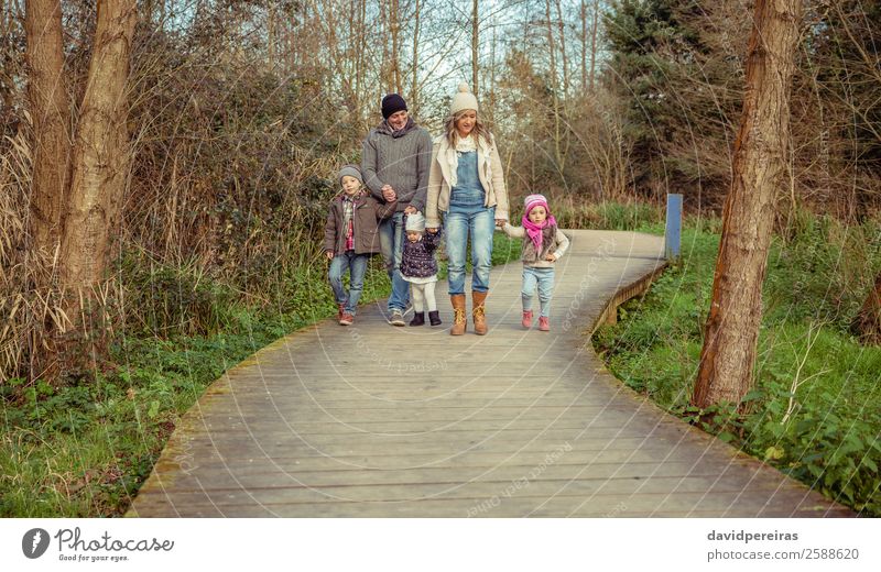 Family walking together over wooden pathway into the forest Lifestyle Happy Beautiful Leisure and hobbies Winter Child Human being Baby Boy (child) Woman Adults