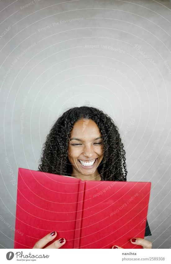 Young happy woman reading a red book Joy Leisure and hobbies Education Study Student Human being Feminine Young woman Youth (Young adults) Woman Adults 1