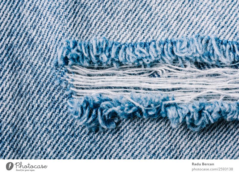 Closeup of torn old blue jeans background. texture of ripped