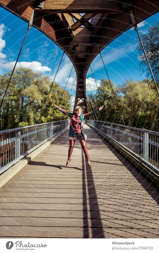 young woman jumps into the air on a wooden bridge 1 Person Young woman Beautiful weather Blue sky Clouds Happiness Free High spirits Jump Bridge Wooden bridge