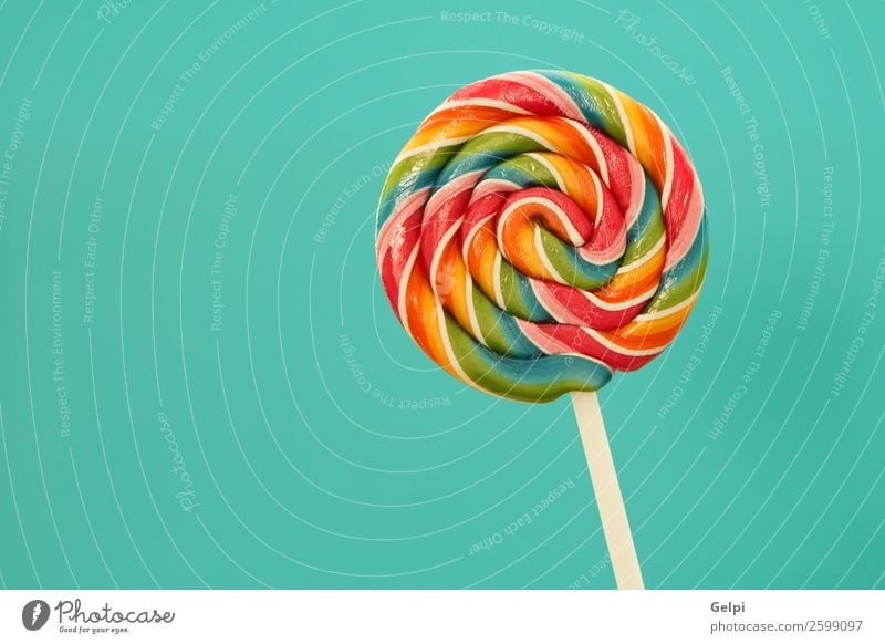 Nice lollipop with many colors in a spiral on a blue background Dessert Eating Joy Infancy Bright Delicious Retro Blue Red White Colour candy food Lollipop