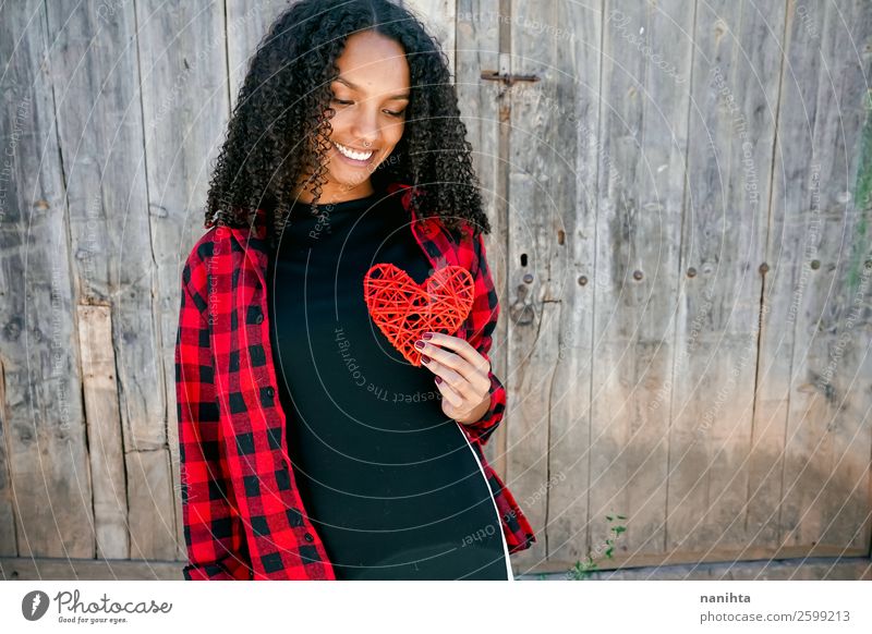 Beautiful young woman holding a red heart Lifestyle Style Joy Hair and hairstyles Human being Feminine Young woman Youth (Young adults) Woman Adults