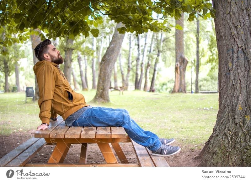 Man sitting in a park, on a picnic table Lifestyle Wellness Well-being Relaxation Vacation & Travel Freedom Young man Youth (Young adults) Body 1 Human being