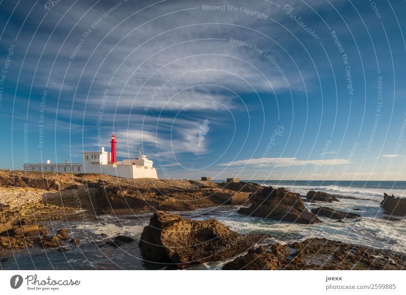 Lighthouse at Portuguese rocky coast at the sea in front of blue sky Wide angle Exterior shot Colour photo Horizon Wanderlust Calm White Brown Blue Maritime Old