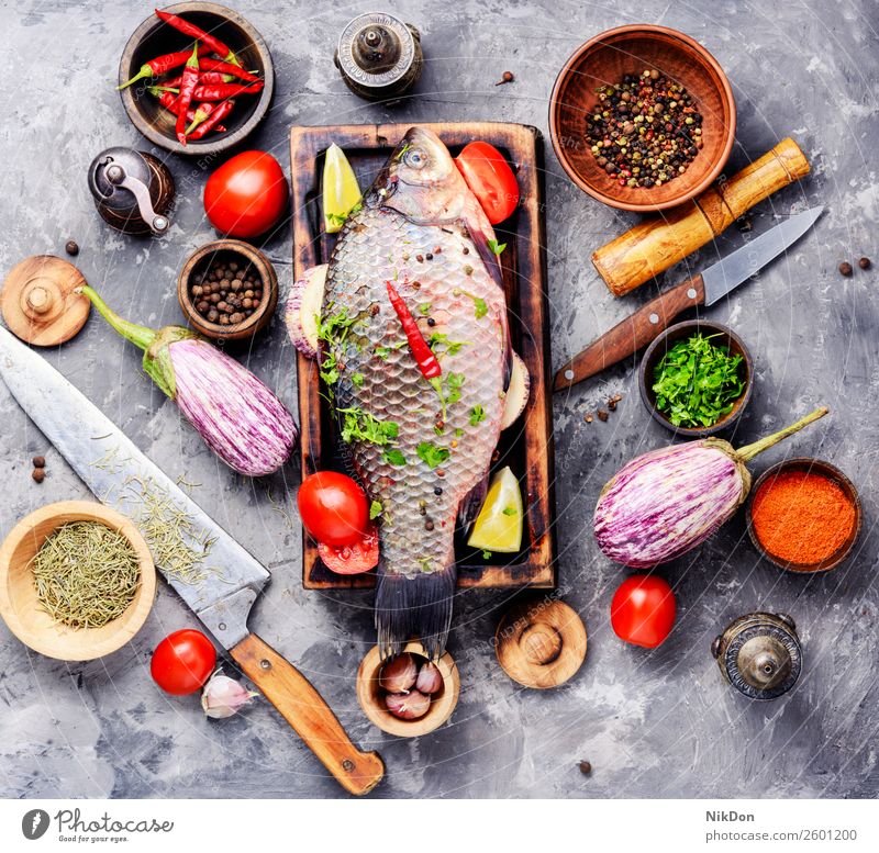 Fresh raw fish and food ingredients carp seafood fresh meal healthy cutting board cooking pepper tomato vegetable preparation spice salt diet uncooked whole