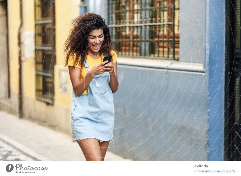 African woman walking on the street looking at her smartphone Lifestyle Style Happy Beautiful Hair and hairstyles Telephone PDA Technology Human being Feminine