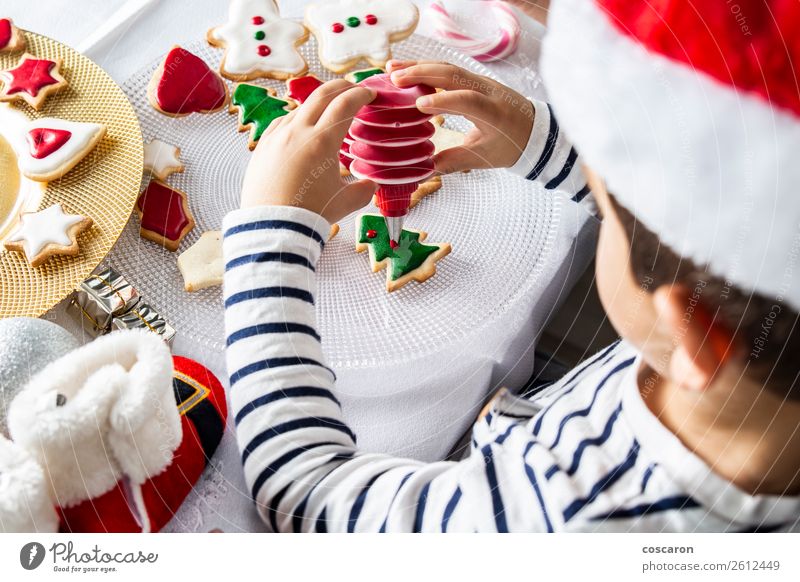Little kid decorating Christmas biscuits at Christmas day Dough Baked goods Dessert Candy Joy Happy Leisure and hobbies Decoration Table Kitchen