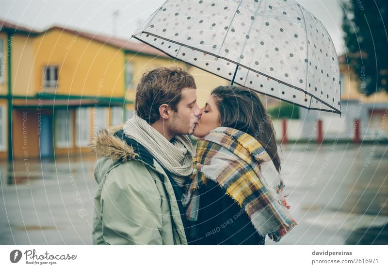 Young couple kissing outdoors under umbrella in a rainy day Lifestyle Happy Beautiful Winter Human being Woman Adults Man Family & Relations Couple Autumn Rain