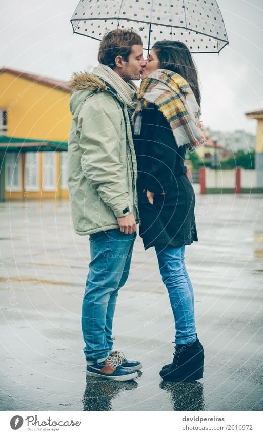 Young couple kissing outdoors under umbrella in a rainy day Lifestyle Happy Beautiful Winter Human being Woman Adults Man Family & Relations Couple Autumn Rain