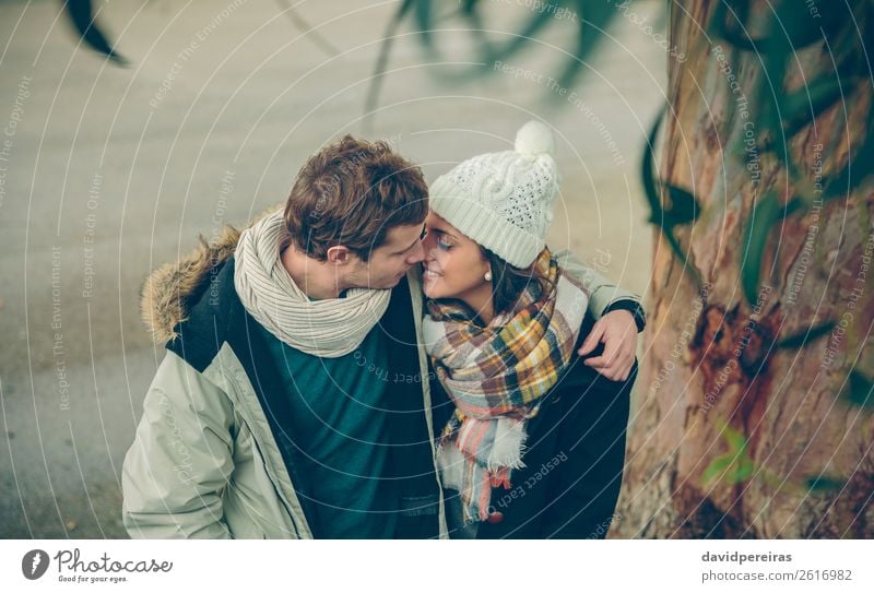 Young couple in love embracing and kissing outdoors Lifestyle Happy Beautiful Winter Human being Woman Adults Man Family & Relations Couple Autumn Rain Tree