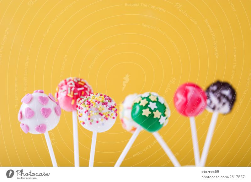 Sweet cake pops on yellow background Baked goods Cake Candy Colour Multicoloured Food Food photograph Lollipop Baking Yellow Dog food stick Pink Dessert Bright