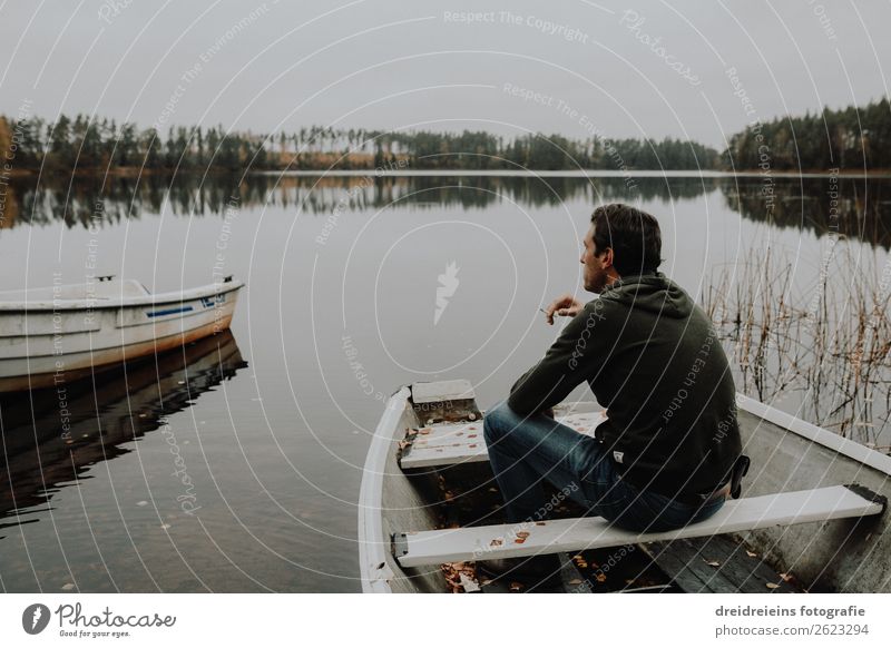 Man sits at sea in a rowboat smoking a cigarette. Adventure Freedom Masculine Adults 1 Human being Landscape Spring Summer Autumn Coast Lakeside Relaxation