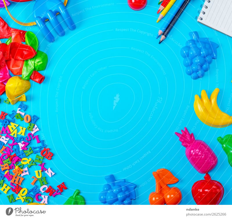 Blue background with childrens plastic toys Playing School Business Paper Pen Toys Balloon Wood Plastic Above Clean Yellow Red White Colour notebook education
