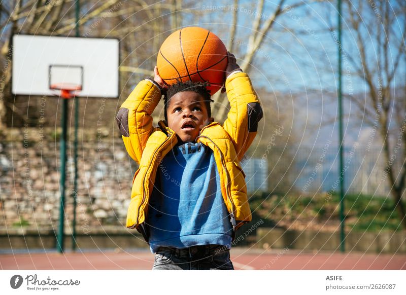 Cute little boy holding a basket ball trying make a score Joy Happy Relaxation Leisure and hobbies Playing Winter Sports Child School Boy (child) Infancy Autumn